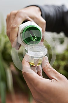 Man measuring a dose of liquid fertilizer photo