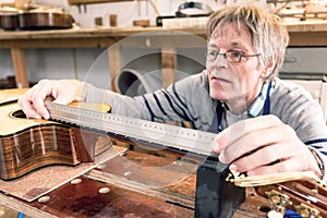 Man measuring the frets on a guitar