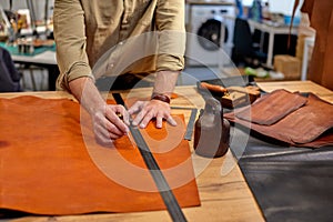 man measuring leather with ruller