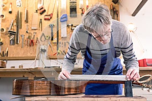 Man measuring the neck of a guitar