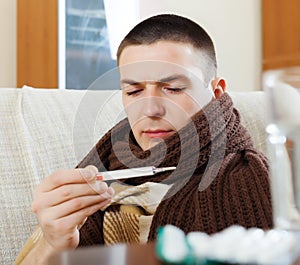 Man measuring temperature with thermometer