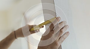 Man measuring a wall using a folding ruler