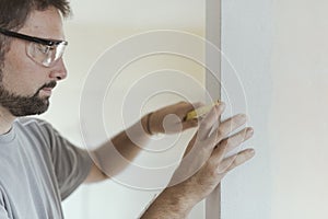 Man measuring a wall using a folding ruler