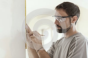 Man measuring a wall using a folding ruler