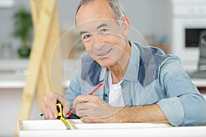 man measuring wood on saw