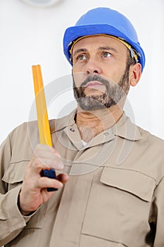 man measuring wood on saw