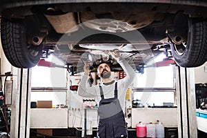 Man mechanic repairing a car in a garage.