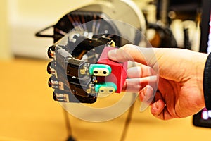 Man and Mechanical Hand Holding a Red Cube in the Research Laboratory