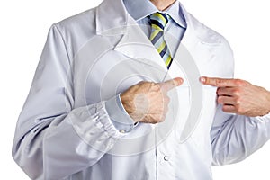 Man in medical coat pointing to his heart with forefingers