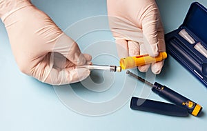 A man in medical gloves holds a syringe for subcutaneous injection of hormonal drugs in the IVF protocol in vitro fertilization Pr