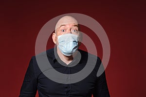 Man with medical mask expresion surprise on red background