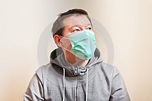 A man in a medical mask looks away, self-isolation, quarantine, stay home, order online