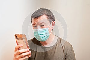 A man in a medical mask looks at the phone, an online order for self-examination, quarantine, stay home, order online