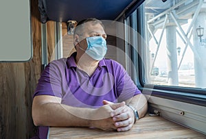 Man in a medical mask near the train car. concept of travel during the pandemic. mode of permanent wearing of a protective medical