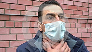 Man in medical mask out of breath, choking, suffocating, ill, heavy cough, breathless, suffer. Portrait