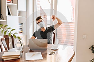 Man in medical mask showing thumb