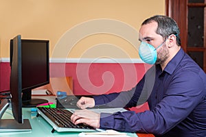 Man with medical mask  working in house. Teleworking concept