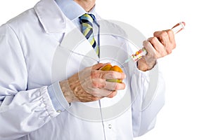 Man in medical white coat makes an injection to beefsteak tomato