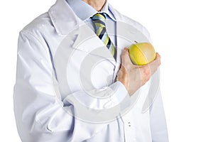Man in medical white coat showing yellow apple