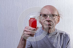 Man with medication. He`s holding an empty pill jar in his hand. Portrait