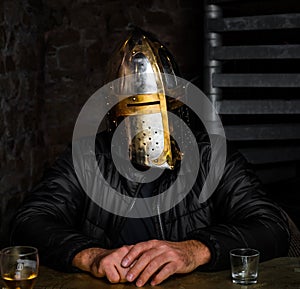 A man in a medieval iron knight`s helmet