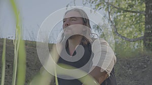 A man in medieval peasant clothing rests under a tree.