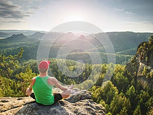 Man meditates in yoga in mountains above wild nature at sunset. Concept of meditation, spirituality and soul balance