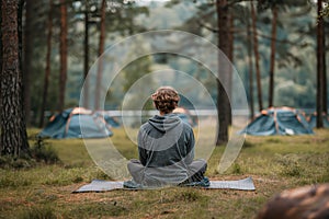 Man meditating alone in forest campsite