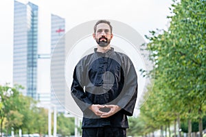 Man meditating doing martial arts in city