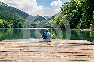 The man meditating in lotus position on Biogradsko lake in the n