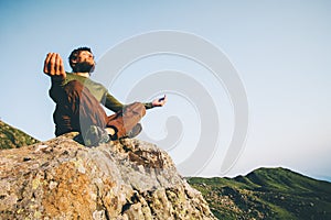 Man meditating yoga lotus pose at mountains