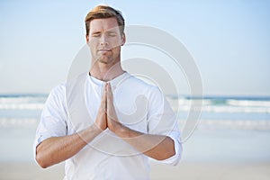 Man, meditation on beach and prayer for zen, wellness and holistic healing outdoor for calm and yoga. Ocean, fresh air