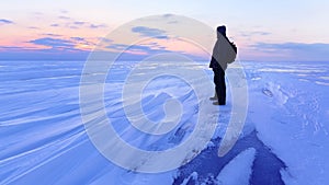 Man meets the dawn on the frozen lake