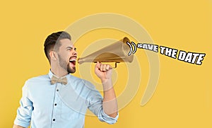 Man with megaphone and phrase SAVE THE DATE on yellow background