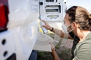 Man mending the varnish of a van