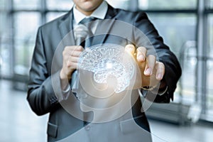 A man with a microphone in his hand is touching a head of a transparent figure with bright digital brain model .