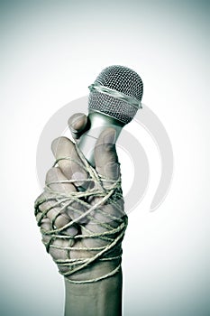 Man with a microphone tied with rope