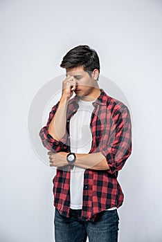 A man with a migraine headache holding her hand in her nose