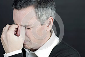 Man With Migraine Holds Bridge Of Nose