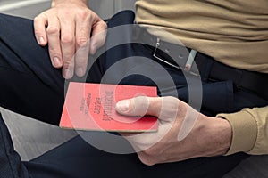 Man with a military ID in his hands is sitting on the floor
