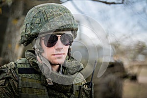 Man is a military man in a helmet and camouflage clothing. pensive soldier is resting from a military operation