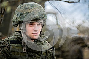 Man is a military man in a helmet and camouflage clothing. pensive soldier is resting from a military operation