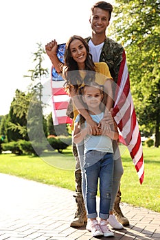 Man in military uniform with American flag and his family