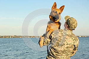 Man in military uniform with German shepherd dog