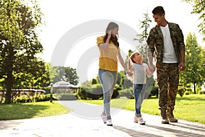 Man in military uniform and his family walkin