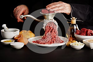 Man mincing beef with grinder in close-up