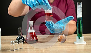a man mixes a liquid in test tubes in a laboratory