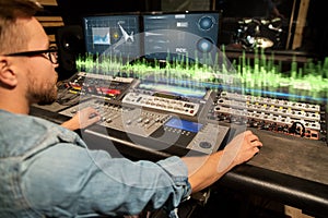 Man at mixing console in music recording studio