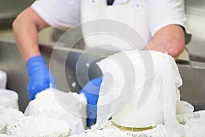 Uomo miscelazione crudo formaggio acciaio inossidabile cisterna durante fermentazione prova sul formaggio produzione pianta 