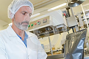 Man in mob cap with sealed plastic bag